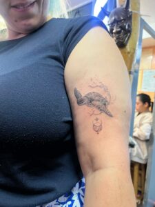 A detailed turtle tattoo featuring a crescent moon and stars, representing harmony and the beauty of the night sky.