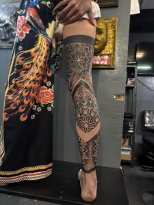 High-contrast realism tattoo of a rose on the inner forearm, featuring heavy blackwork and fine-line petal shading.